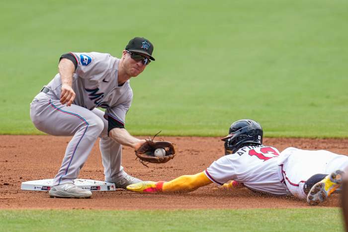Jul 2, 2023; Cumberland, Georgia, USA; Atlanta Braves right fielder Ronald Acuna Jr. (13) steals second base under Miami Marlins shortstop Joey Wendle (18) during the first inning at Truist Park.